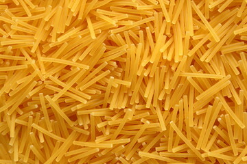 Close-up macro shot of the spaghetti tagliati pasta lying on a flat surface.