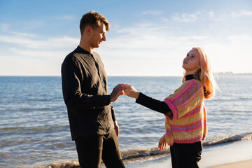 Happy couple hugging on the seashore at sunset of the day. Walk near the sea. Romantic time. Happy young people. Valentines day