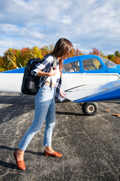 Young BIPOC Female Pilot doing preflight check on small plane