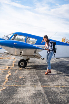 Young BIPOC Female Pilot doing preflight check on small plane