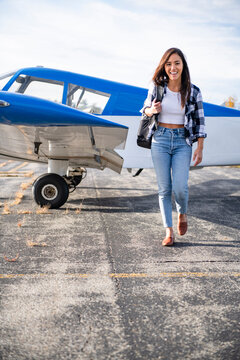 Young BIPOC Female Pilot doing preflight check on small plane