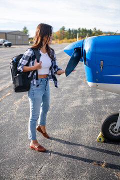 Young BIPOC Female Pilot doing preflight check on small plane