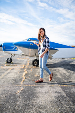 Young BIPOC Female Pilot doing preflight check on small plane