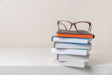 Glasses on a stack of books on light background. Education. learning and back to school concept.
