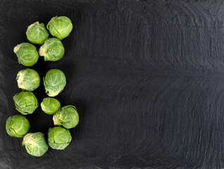 Fresh raw organic brussel sprouts on black stone setting
