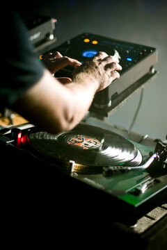 Close up of a DJ's hands performing at a rave party.