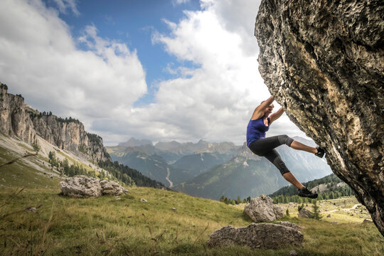 Young Woman Bouldering In The Dolomites