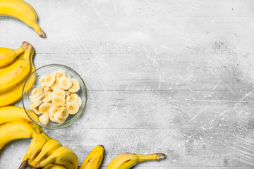 Bananas and banana slices in a glass plate.