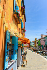 Bicycles parked in front of a brightly colored souvenir shop. Colorful houses in Burano Island. Famous travel destination, Venice, Italy