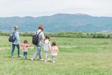 ママ友家族を公園を歩く親子の後ろ姿（女友達・母子家庭）
