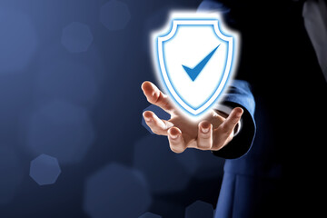 Anti-fraud security system. Man with illustration of checkmark in shield on dark background,...