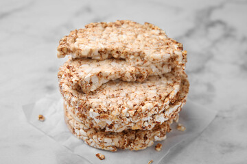Stack of crunchy buckwheat cakes on white marble table, closeup