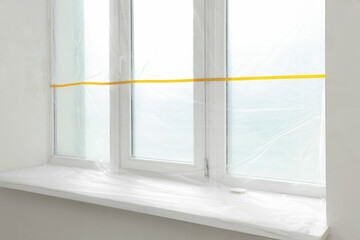 Window covered with polyethylene film. Protection during repair