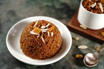 Homemade broken wheat sweet chakarai pongal topped with nuts and raisins, selective focus