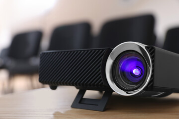 Modern video projector on table in conference room