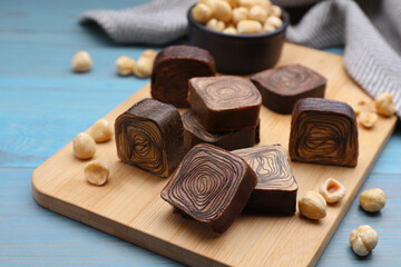 Tasty chocolate candies on light blue wooden table