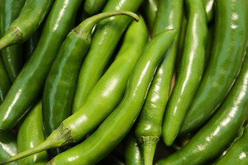 Green hot chili peppers as background, closeup