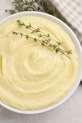 Bowl of tasty mashed potato with rosemary on grey marble table, flat lay
