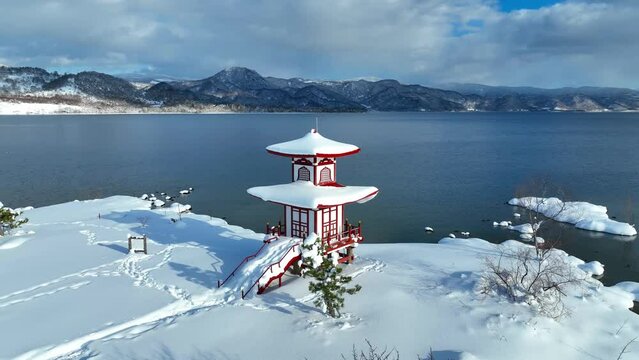 Japanese traditional pagoda in the snow in winter, beautiful winter lake in Asia, tourism in Asia in winter, Japanese culture, snowy meditation landscape