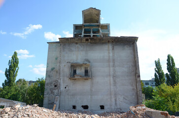 Collapsed industrial multistorey building in daytime. Disaster scene full of debris, broken bricks...
