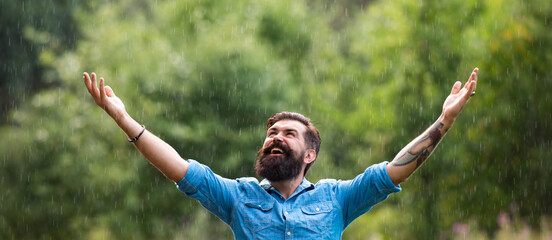 Man on spring rain, banner. Relaxation and positive. Stormy weather. Bearded man under rain.