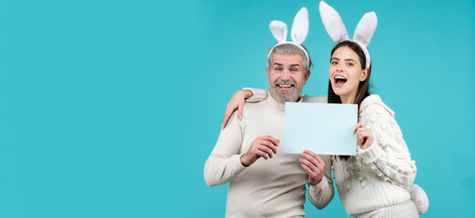 Happy easter for your company. Bunny: upset rabbit couple. Portrait of happy Easter bunny man and woman hold board paper for text. Horizontal photo banner for website header design.