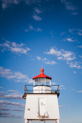 Fototapeta na wymiar White lighthouse with red top