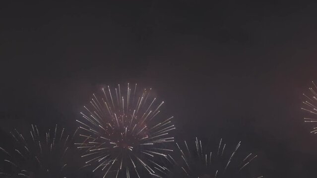 Colorful fireworks festival. Beautiful fireworks close-up view in slow motion. Wonderful real fireworks in the night sky shot with a telephoto lens. fireworks show. 4K slow motion video.