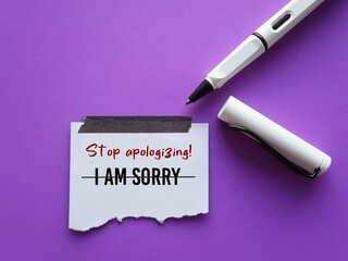 On purple background, pen writes on stick note I AM SORRY crossed off to Stop Apologizing, concept of stop being low self-respect by saying sorry too often every little thing that goes wrong - obrazy, fototapety, plakaty