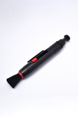 Black and red lens pen, closeup and isolated on white background. camera equipment for cleaning lenses