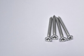 Close-up on screws, metal screws, iron screws, isolated on whited background. Flat Head