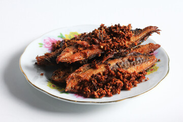 Tongkol goreng bawang or fried tuna mackerel, Indonesian easy and cheap authentic food recipe, served on plate, isolated on white background.