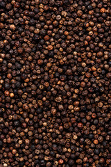 Black pepper, peppercorns, dry spice, food background texture, top view