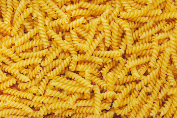 Raw dry fusilli pasta, food background texture, top view