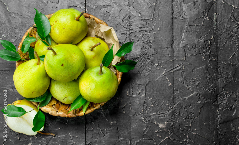 Wall mural Fresh pears with leaves in basket.