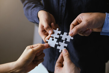 Business people with jigsaw puzzle pieces in office, Successful teamwork and partnership concept. - obrazy, fototapety, plakaty