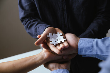 Business people with jigsaw puzzle pieces in office, Successful teamwork and partnership concept.
