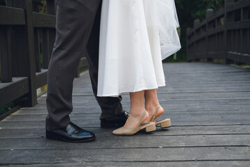 Close-up of newlyweds 
stylish shoes of bride and groom outdoors, Wedding day Concept.