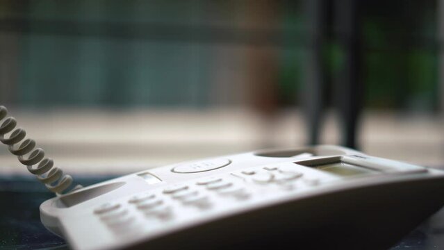 Man hand office worker picking up the phone to answer a phone call whilst working at his desk. pick up the phone and answer the call. retro telephone. High quality 4k footage