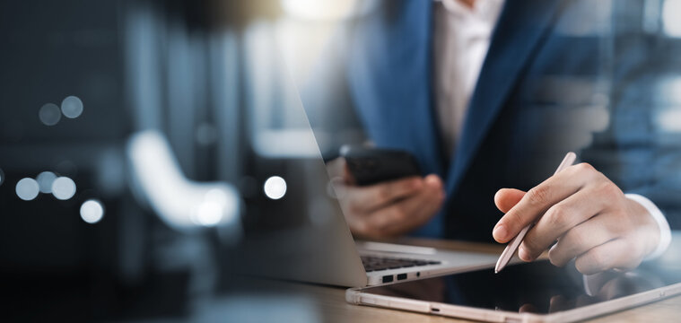 Businessman Working On Laptop Computer And Tablet On Table At Office, Working Online Use A Stylus On A Digital Tablet Screen.