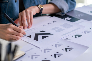 Graphic designer drawing sketches logo design. The concept of a new brand. Professional creative...