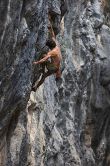 Strong man climbing a rock.