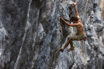 Strong man climbing a rock.