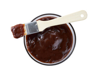 Barbecue sauce in bowl with barbecue brush isolated on a white background, top view.