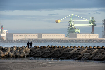火力発電所の堤防で釣りをする男性