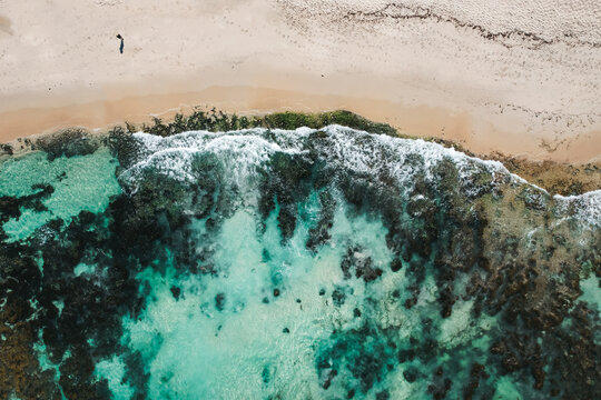 Top down view of the coastline of Perth with woman standing on the beach.