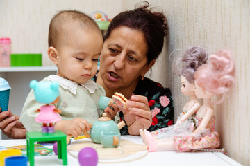 Grandmother and toddler playing with toys at home
