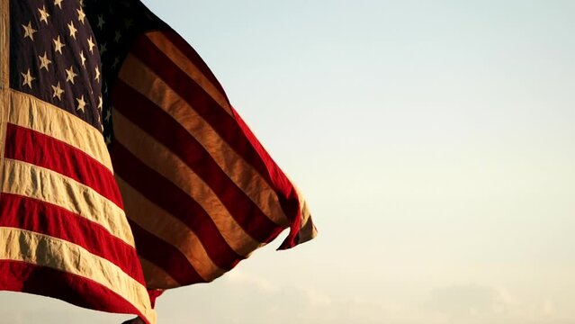 Close-up American USA flag waving in the wind against sunset nature outdoor background, Slow Motion. Concept of 4th of July, Memorial Day, Independence Day, Veterans Day, Patriots, Labor