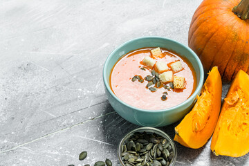 Pumpkin soup with slices of ripe pumpkin and seeds.
