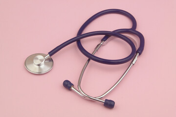 Stethoscope on pink background close up. Healthcare and medicine concept.